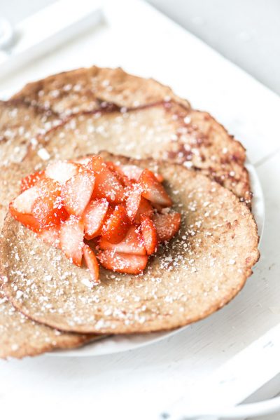 Afbeelding van ontbijt pannenkoeken geserveerd met aardbeien en kokosrasp
