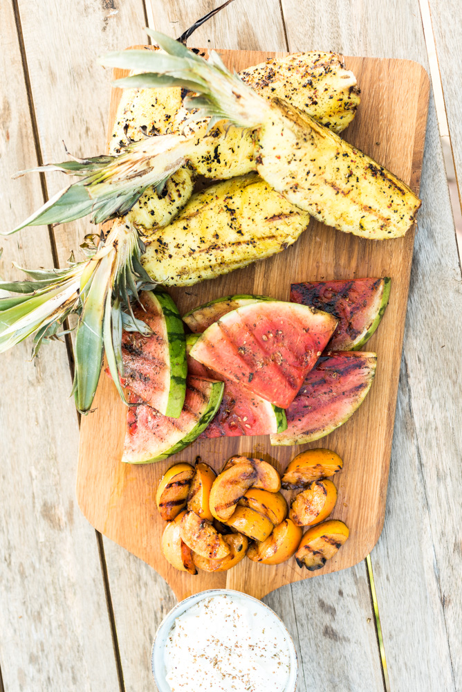 Plank met ananas, watermeloen en kaki gegrild van de barbecue