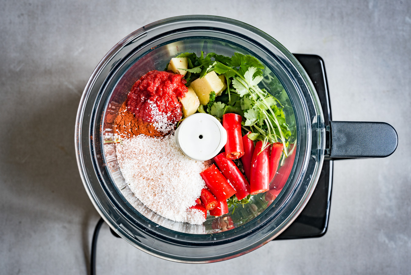 Afbeelding van alle ingrediënten voor tikka masala die in de keukenmachine zitten 